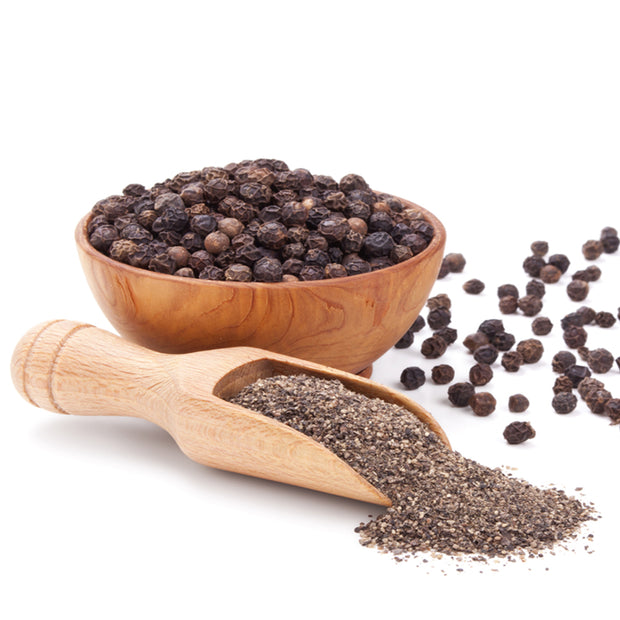 whole black pepper and ground pepper in spoon and bowl